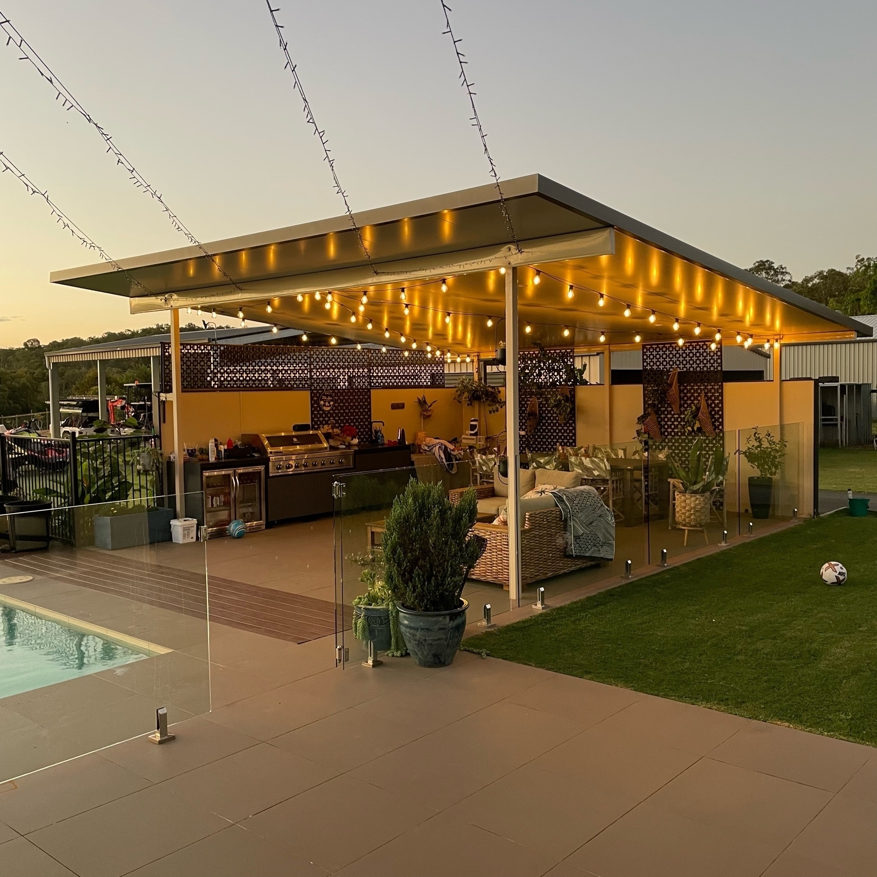 An outdoor dining and relaxation area; lit with festoon lighting.
